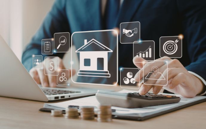person on laptop with calculator and money